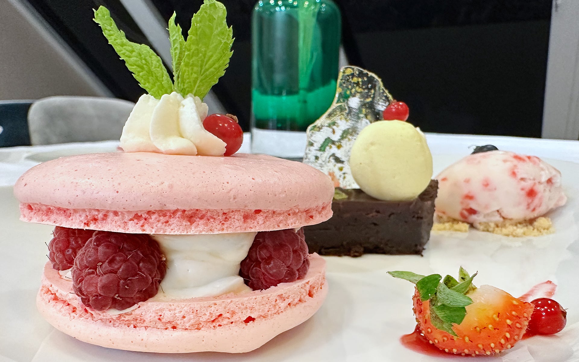 A Rasberry Macaroon on a plate with ice cream.