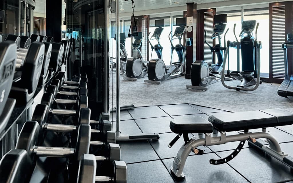 Free weights and exercise machines in the Azamara Onward gym.
