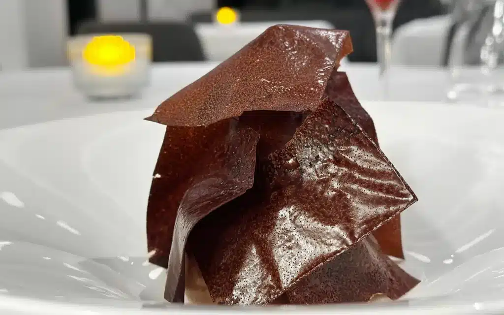 A chocolate dessert served on a white plate.